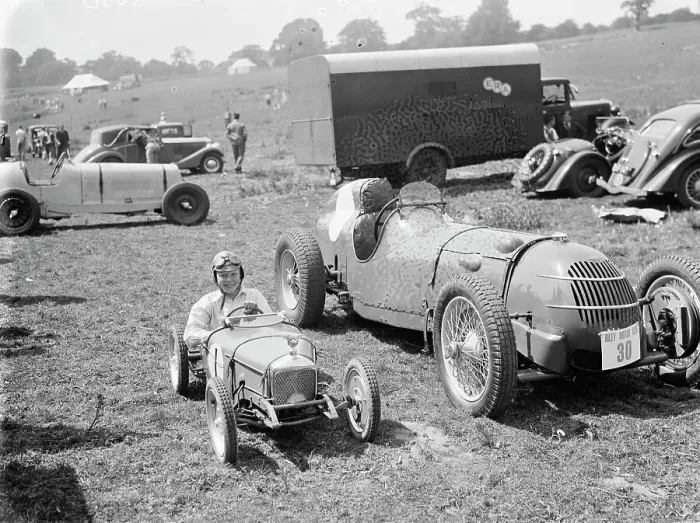 Framed Print : Peter McClure sits in a toy race car, parked next to the real thing, in Lullingstone Framed Print : Peter McClure sits in a toy race car, parked next to the real thing, in Lullingstone