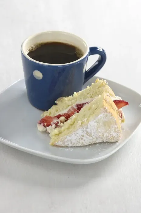 Framed Print : A piece of strawberry sponge cake on a white plate with a small blue and white spotted
