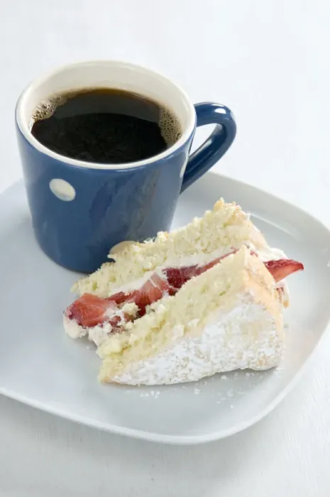 Framed Print : A piece of strawberry sponge cake on a white plate with a small blue and white spotted