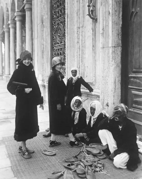 Framed Print : A preliminary to sight seeing. Tourists putting on special shoes before entering