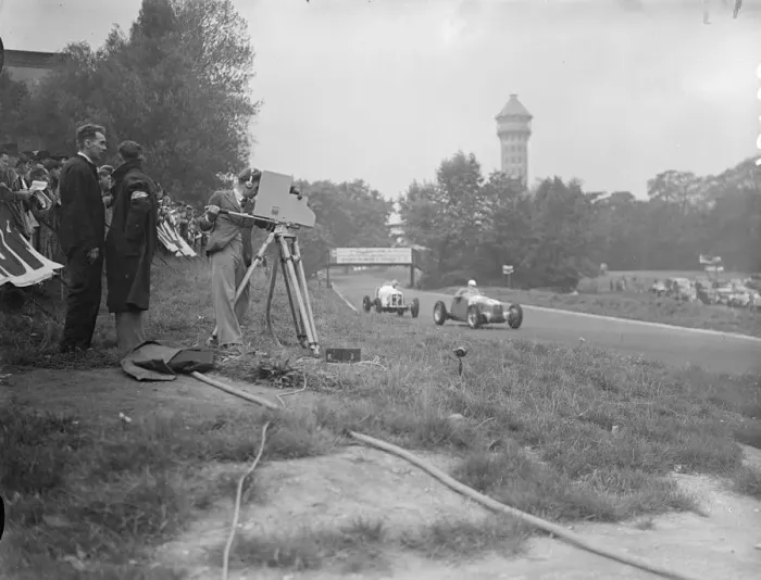 Framed Print : The race being televised in front is count Johnny Lurani the Italian driver in his Maserati