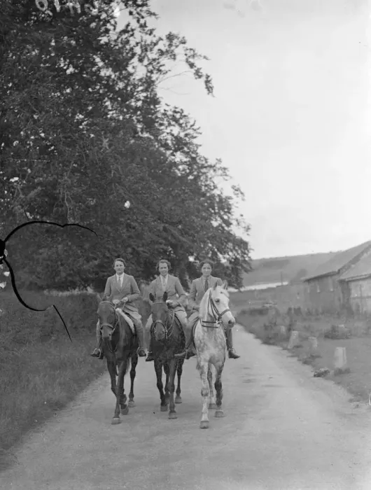 Framed Print : Riders passing through a tree-lined country lane near Warnford, Hampshire, on their
