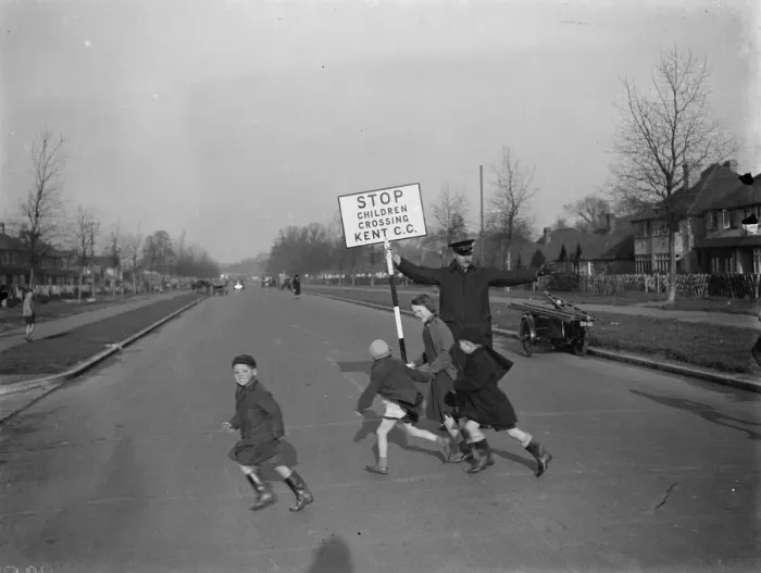 Framed Print : Road attendant from Kent County Council, holding a sign, helps children in St Mary Framed Print : Road attendant from Kent County Council, holding a sign, helps children in St Mary
