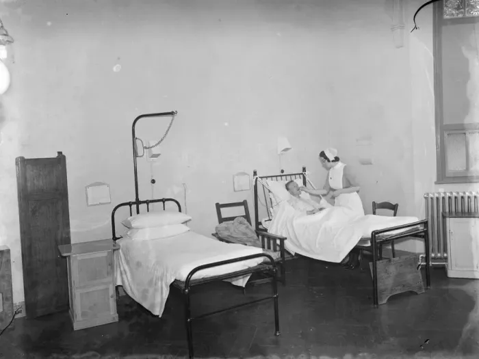 Framed Print : The Sidcup Cottage Hospital in Kent. A nurse tends to a patient in the mens ward Framed Print : The Sidcup Cottage Hospital in Kent. A nurse tends to a patient in the mens ward