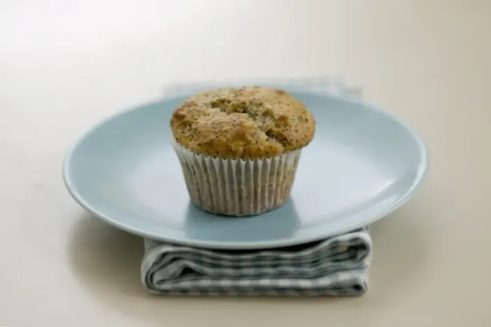 Framed Print : Single poppyseed muffin on blue plate on check napkin, on painted table. credit Framed Print : Single poppyseed muffin on blue plate on check napkin, on painted table. credit