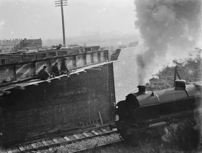 Framed Print : Steam engine passing by the building work being carried out for the widening of Framed Print : Steam engine passing by the building work being carried out for the widening of