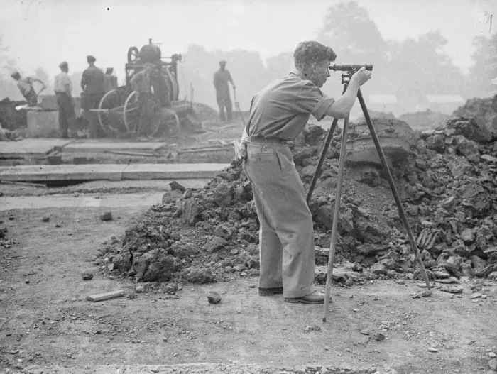 Framed Print : A surveyor at work during the excavations on the site of a bomb proof shelter to Framed Print : A surveyor at work during the excavations on the site of a bomb proof shelter to