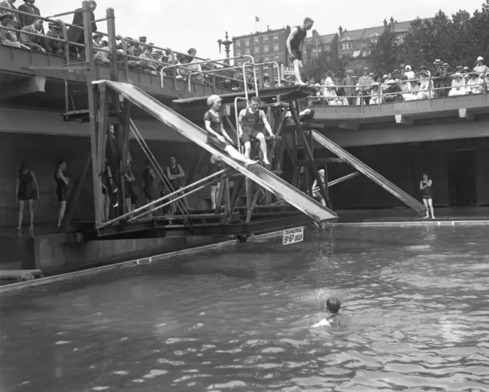 Framed Print : Swimmers enjoying the water chute and diving boards at the open air swimming pool Framed Print : Swimmers enjoying the water chute and diving boards at the open air swimming pool