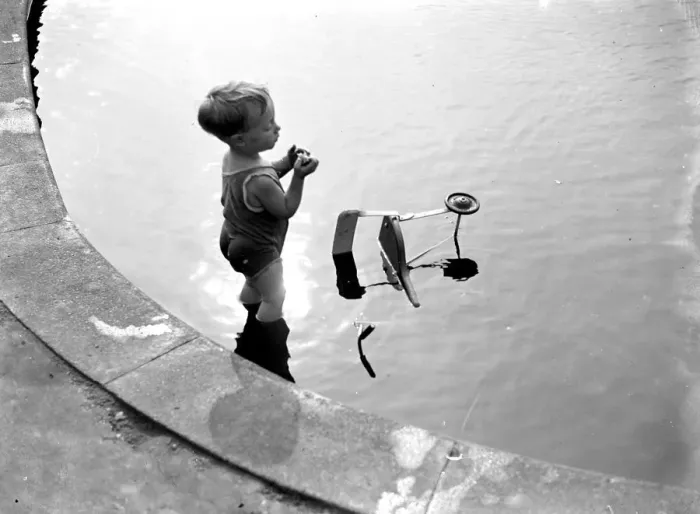 Framed Print : Toddler and his trike in the water. 1933