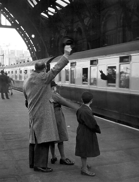 Train leaving St Pancras Station 1940 s. Father and sons waving goodbye from the platform