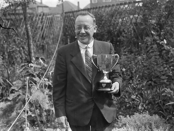 A W Costley, the Secretary of Crayford Horticultural Society, posing with his trophy