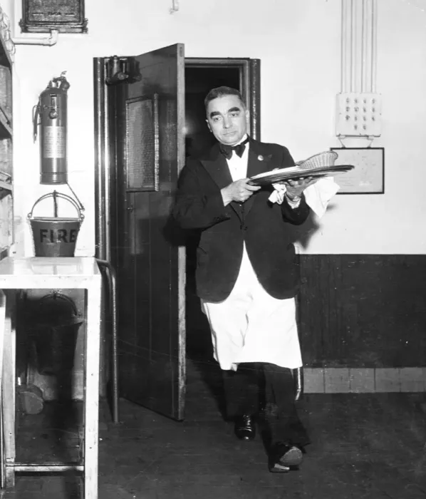 Framed Print : A waiter rushes through the kitchen door with a tray of food during the rush for orders at lunch