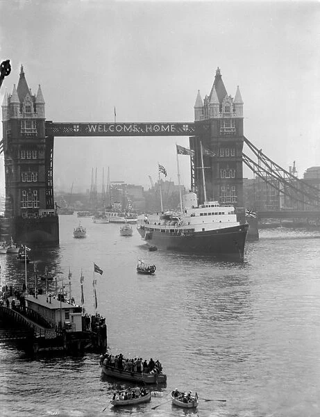 Through the welcoming Tower Bridge slowly moves the Royal Yacht Britannia as she