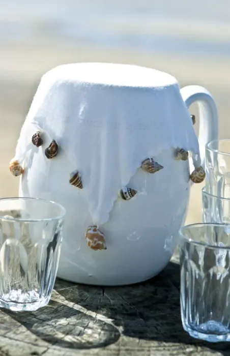 Framed Print : White jug with white fabric cover weighted with sea shells to keep insects out. credit Framed Print : White jug with white fabric cover weighted with sea shells to keep insects out. credit
