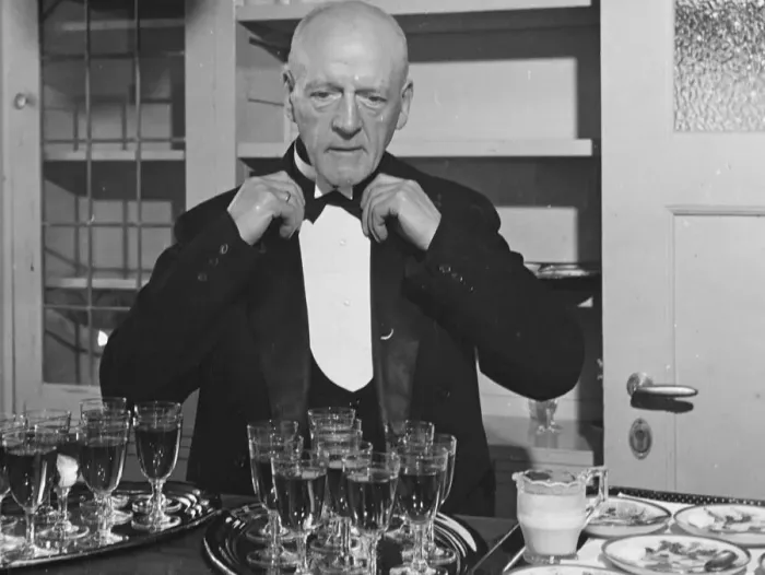 Framed Print : A wine waiter fixes his bow tie. undated Framed Print : A wine waiter fixes his bow tie. undated