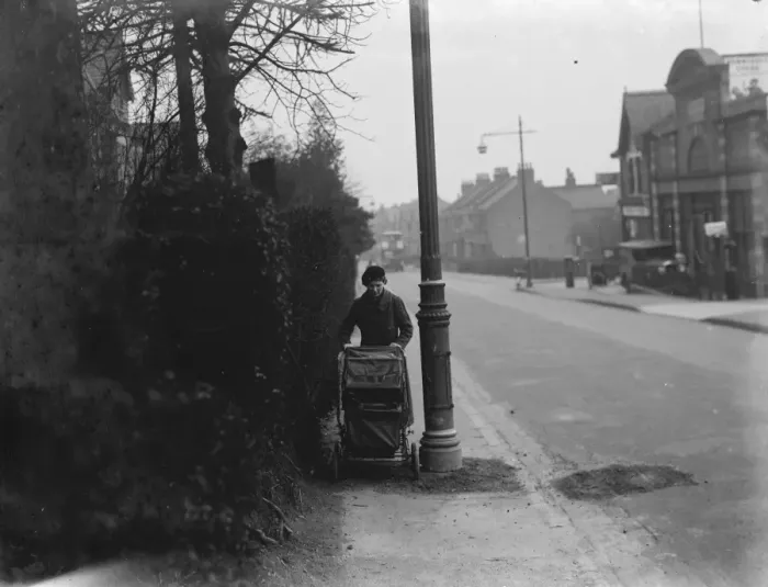 Framed Print : A woman pushes a pram past a street light which is shrouded by branches in Sidcup, Kent Framed Print : A woman pushes a pram past a street light which is shrouded by branches in Sidcup, Kent