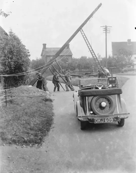 Framed Print : workers use ladders and poles erect an electric pylon next to a road in Trottiscliffe Framed Print : workers use ladders and poles erect an electric pylon next to a road in Trottiscliffe