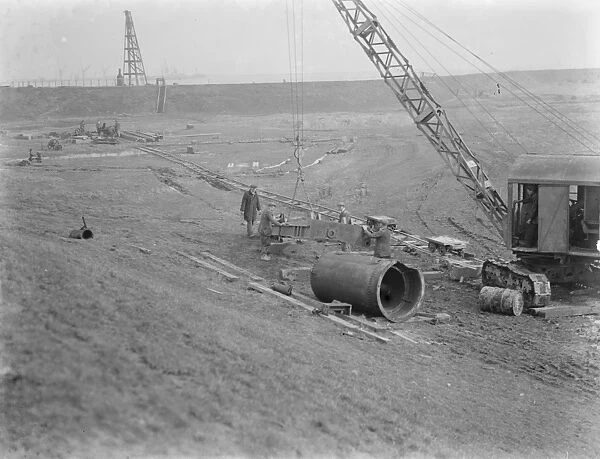 Workmen using a crane for the construction of the Dartford Tunnel. Work begins