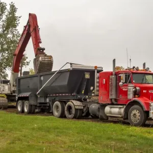 Un unidad de almacenamiento Kenworth rojo de 6x4 con un remolque de eje doble que se derrama siendo cargado en Sudbury. Un unidad de almacenamiento Kenworth rojo de 6x4 con un remolque de eje doble que se derrama siendo cargado en Sudbury.