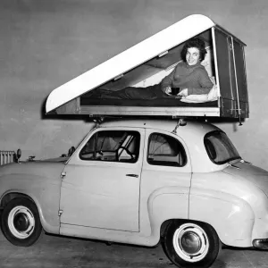 Print of a woman demonstrating the mo-bed, a car roof-top sleeping compartment Print of a woman demonstrating the mo-bed, a car roof-top sleeping compartment
