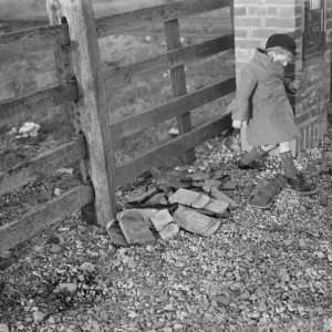 Children playing on the shingle beach at Dungeness. A child trys on a special Children playing on the shingle beach at Dungeness. A child trys on a special