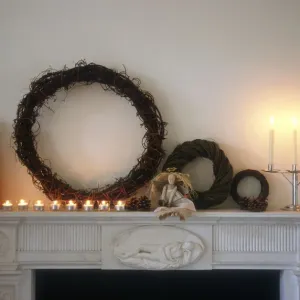Chimney piece in pale interior with shaker style chritmas decorations and objects
