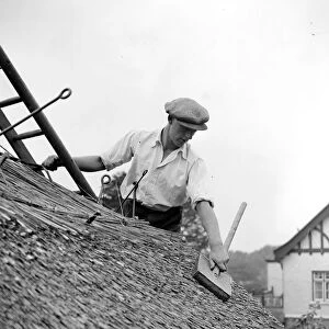 The craft of thatching - At work on thatching the picturesque Old Cottage at the