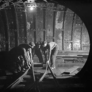 The Dartford tunnel men working the pipes. 1938