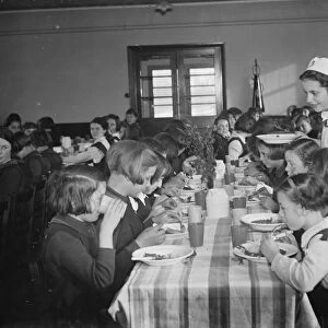 The dinner lady serving lunch at a girls school in Orpington, Kent. 1937