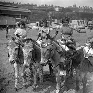Donkeys on the sands at Ramsgate beach with their happy young riders. 22 May 1926