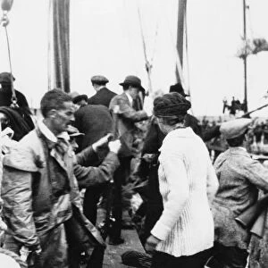 Erskine Childers (in oilskins) as arms landed from the Asgard at Howth in 1914 Aboard