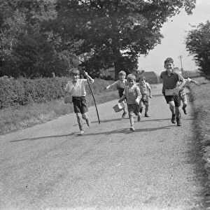 Evacuated children in Wye, Kent, running down a country road. 1939 / 40