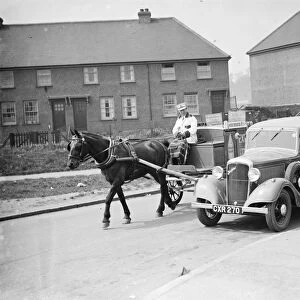 A Express Dairy Delivery horse and cart overtakes an Express Dairy Delivery Bedford van