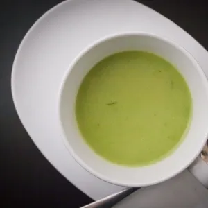 Fresh chilled summer soup of frozen peas, chicken stock, cumin and tarragon