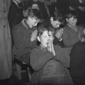 Gypsy childrens Sunday school in the cow shed in St Mary Cray. Children praying