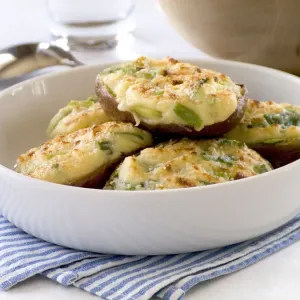 Halved baking potatoes baked with topping of cheese and spring onions credit: Marie-Louise Halved baking potatoes baked with topping of cheese and spring onions credit: Marie-Louise