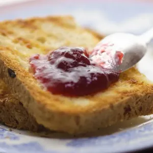 Home made jam on toast made from gluten free bread with silver spoon