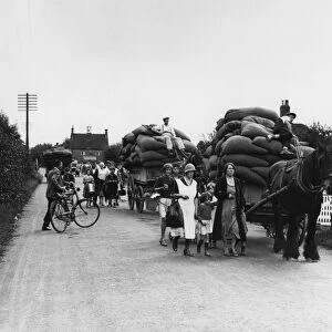 Hop pickers returning from the Kent fields loaded up with full sacks of hops - 1935