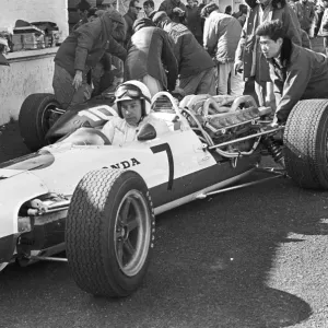 Japanese mechanic pushing John Surtees Honda car during testing at Brands Hatch