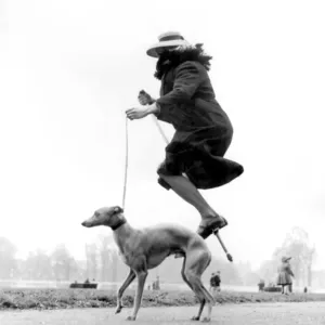 A woman stands on a pogo stick, in mid-air. Print of a vintage photograph A woman stands on a pogo stick, in mid-air. Print of a vintage photograph