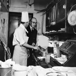 In the kitchen of the restaurant car, the chef M. Roche consults the Maitre d Hotel about breakfast In the kitchen of the restaurant car, the chef M. Roche consults the Maitre d Hotel about breakfast
