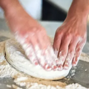 Kneading pizza dough on stainless steel surface. credit: Marie-Louise Avery / thePictureKitchen Kneading pizza dough on stainless steel surface. credit: Marie-Louise Avery / thePictureKitchen