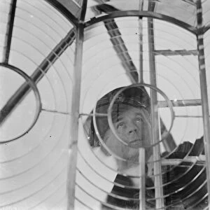 A lighthouse keeper checks the Dungeness lighthouse lantern glass in the lantern room