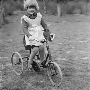 Little Ann Bowers playing on her tricycle with her tame jackdaw sitting on the handlebars Little Ann Bowers playing on her tricycle with her tame jackdaw sitting on the handlebars
