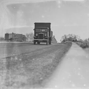 A lorry drives down the road - seen from the curb edge. 1936