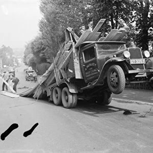 A lorry tips backwards, spilling its load in Sevenoaks, Kent. 1935