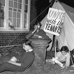 Lying close to their picket tent, youngsters keep a lonely vigil outside Kennistoun House