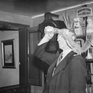 A man gives a drink to a tamed squirrel that is perched on his shoulder A man gives a drink to a tamed squirrel that is perched on his shoulder