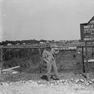 A man by a protest sign in a derelict site at Kingsdown, Kent. 1935