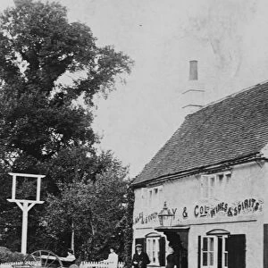 A man with a small cart outside public house at Eversley 1906